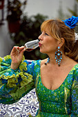 Blond Spanish woman drinking glass of fino sherry, Fuengirola Feria, Andalucia, Costa del Sol, Spain, Europe  (Model released)